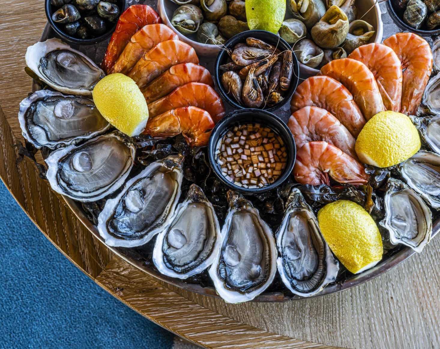 plateau de fruits de mer deauville avec un assortiment de fruits de mer frais comprenant des huîtres, des crevettes, des moules et des coquilles Saint-Jacques sur un plateau de glace avec des tranches de citron et des sauces d'accompagnement.